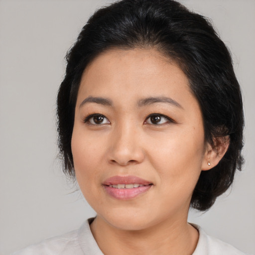 Joyful asian adult female with medium  black hair and brown eyes
