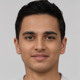 Joyful latino young-adult male with short  brown hair and brown eyes