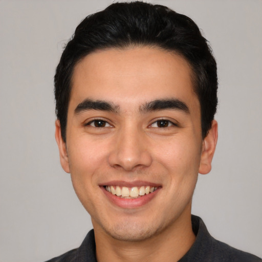 Joyful white young-adult male with short  black hair and brown eyes