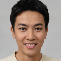 Joyful asian young-adult male with short  brown hair and brown eyes