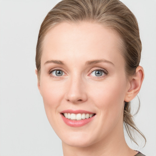 Joyful white young-adult female with medium  brown hair and blue eyes