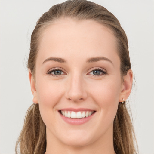 Joyful white young-adult female with long  brown hair and blue eyes