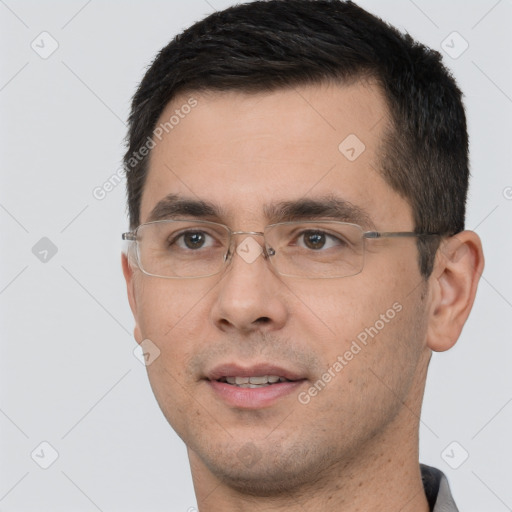 Joyful white young-adult male with short  black hair and brown eyes