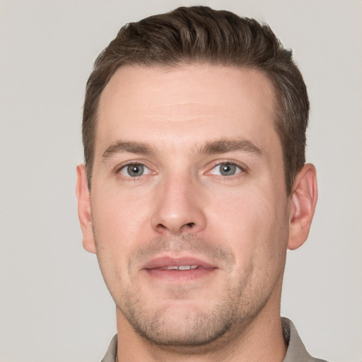 Joyful white young-adult male with short  brown hair and grey eyes