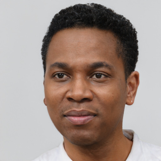 Joyful black young-adult male with short  black hair and brown eyes