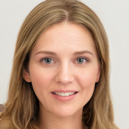 Joyful white young-adult female with long  brown hair and green eyes