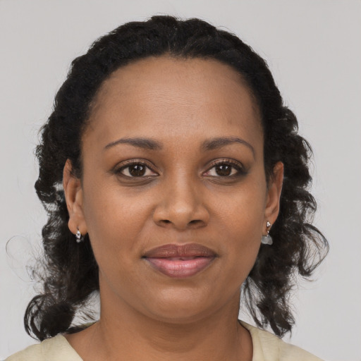 Joyful black adult female with medium  brown hair and brown eyes