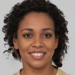 Joyful black young-adult female with medium  brown hair and brown eyes