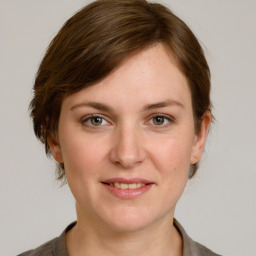 Joyful white young-adult female with medium  brown hair and grey eyes