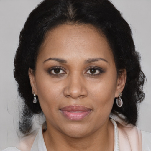 Joyful latino adult female with medium  brown hair and brown eyes