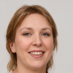 Joyful white young-adult female with medium  brown hair and blue eyes