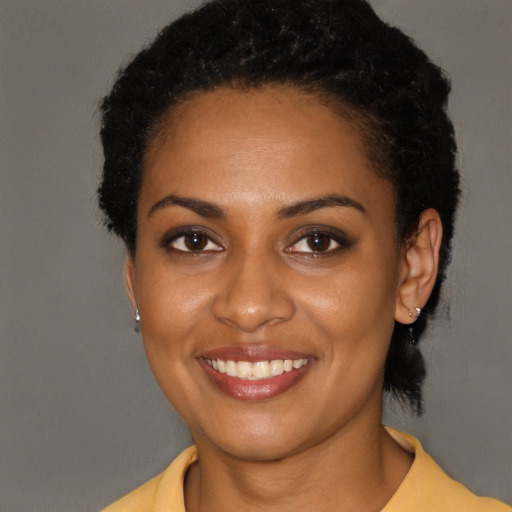 Joyful black young-adult female with short  black hair and brown eyes