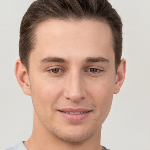 Joyful white young-adult male with short  brown hair and grey eyes