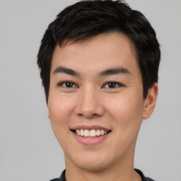 Joyful asian young-adult male with short  brown hair and brown eyes