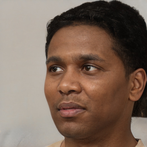 Joyful black young-adult male with short  black hair and brown eyes