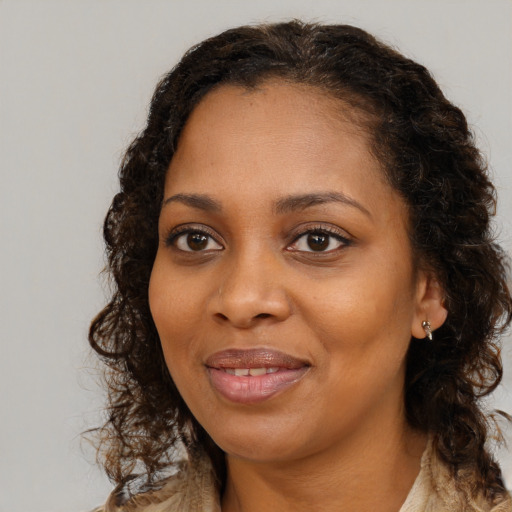 Joyful black young-adult female with long  brown hair and brown eyes