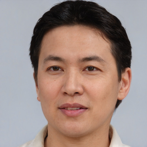 Joyful asian adult male with short  brown hair and brown eyes