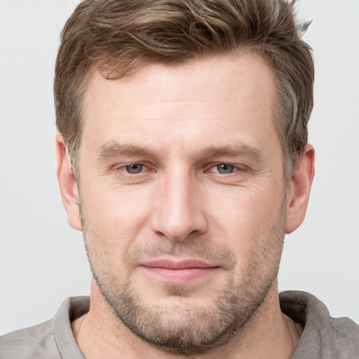 Joyful white adult male with short  brown hair and grey eyes