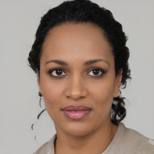 Joyful black young-adult female with short  black hair and brown eyes