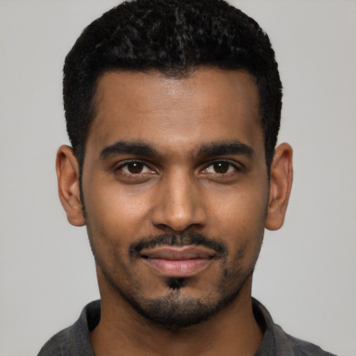 Joyful black young-adult male with short  black hair and brown eyes
