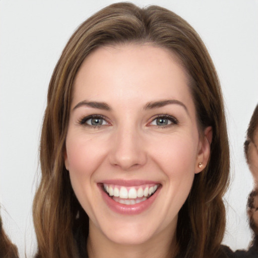 Joyful white young-adult female with long  brown hair and brown eyes