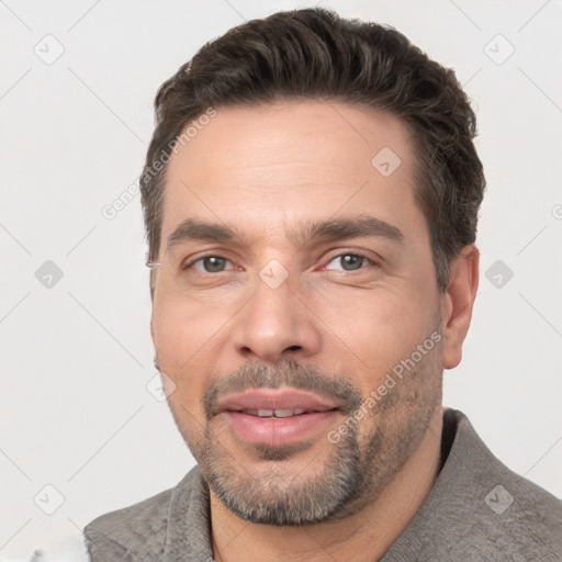 Joyful white adult male with short  brown hair and brown eyes