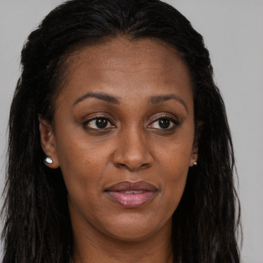 Joyful black young-adult female with long  brown hair and brown eyes