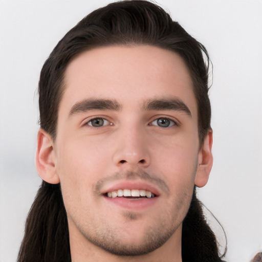 Joyful white young-adult male with long  black hair and brown eyes