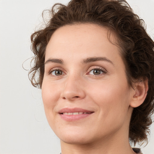 Joyful white young-adult female with medium  brown hair and green eyes