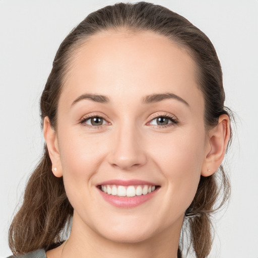 Joyful white young-adult female with medium  brown hair and grey eyes