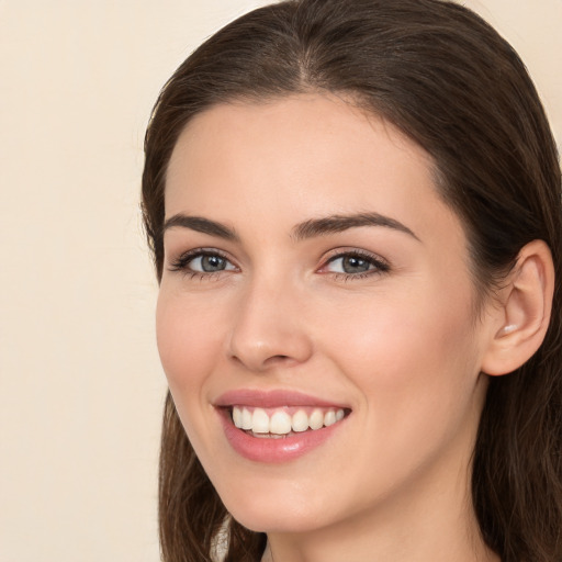 Joyful white young-adult female with long  brown hair and brown eyes