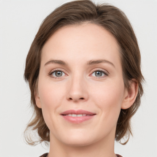 Joyful white young-adult female with medium  brown hair and green eyes