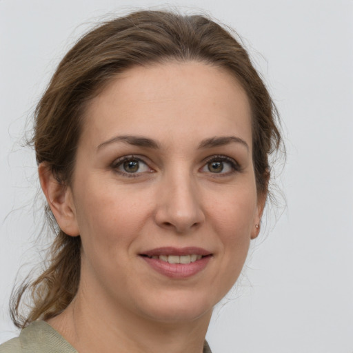 Joyful white young-adult female with medium  brown hair and grey eyes