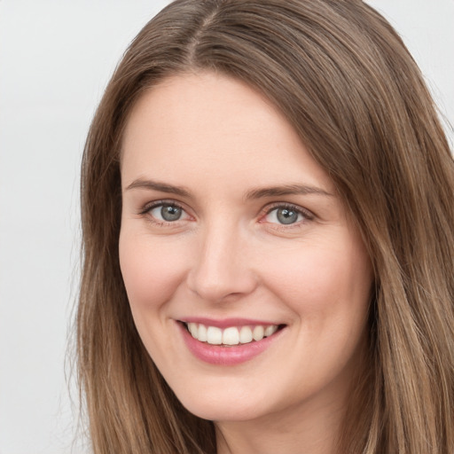 Joyful white young-adult female with long  brown hair and grey eyes