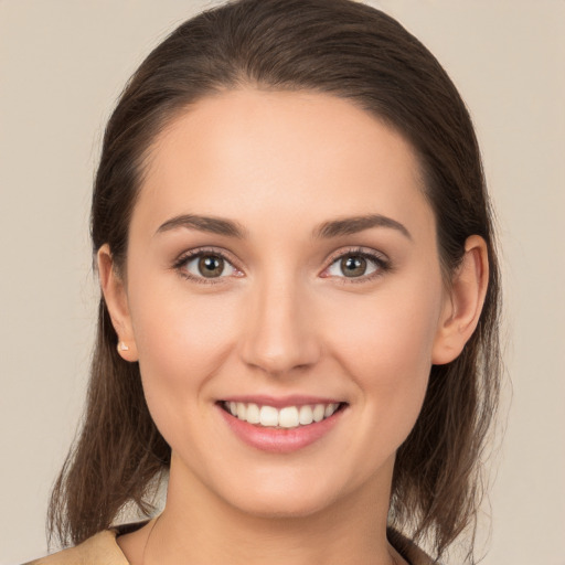 Joyful white young-adult female with long  brown hair and brown eyes