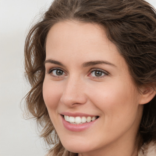 Joyful white young-adult female with medium  brown hair and green eyes