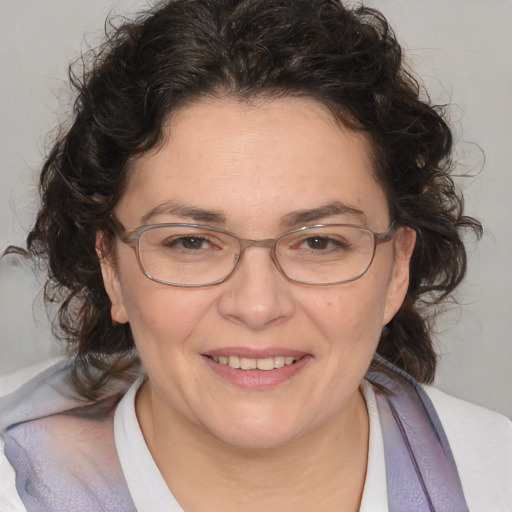 Joyful white adult female with medium  brown hair and blue eyes