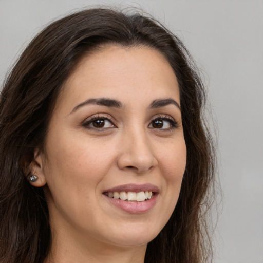 Joyful white young-adult female with long  brown hair and brown eyes