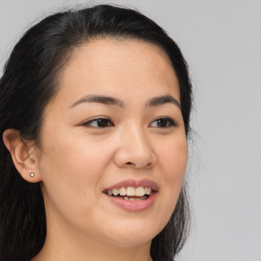 Joyful asian young-adult female with long  brown hair and brown eyes