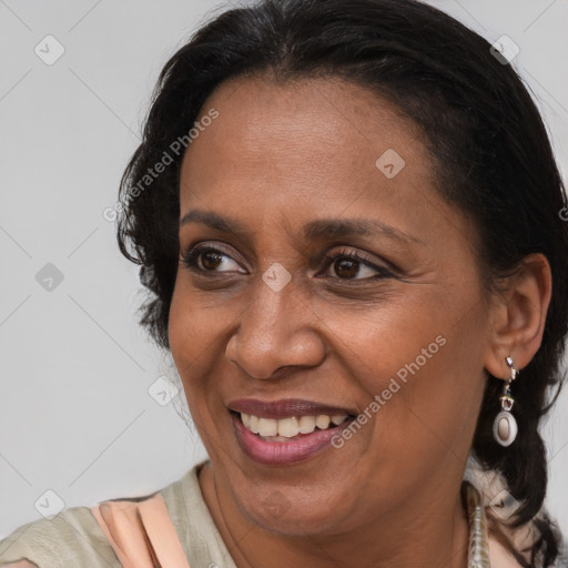 Joyful latino adult female with medium  brown hair and brown eyes