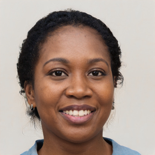 Joyful black young-adult female with long  black hair and brown eyes