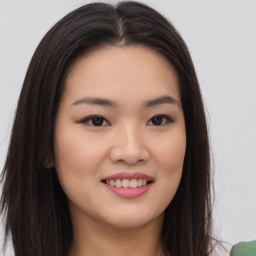 Joyful asian young-adult female with long  brown hair and brown eyes