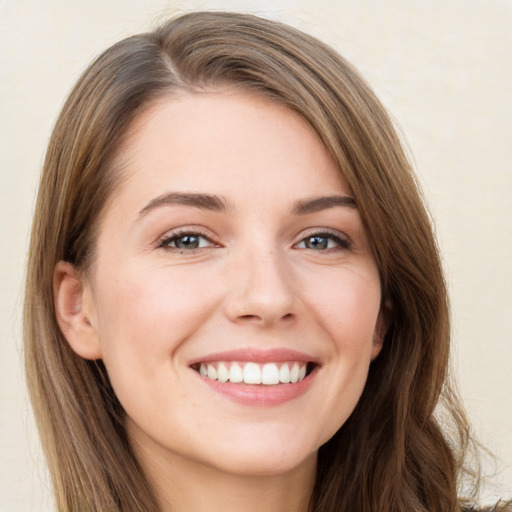 Joyful white young-adult female with long  brown hair and green eyes