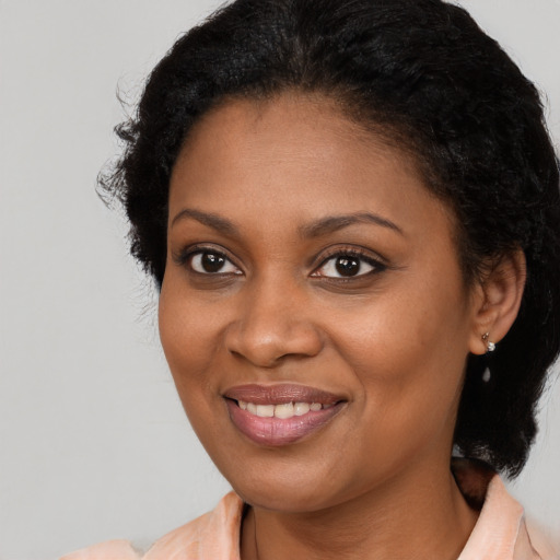 Joyful black young-adult female with long  brown hair and brown eyes