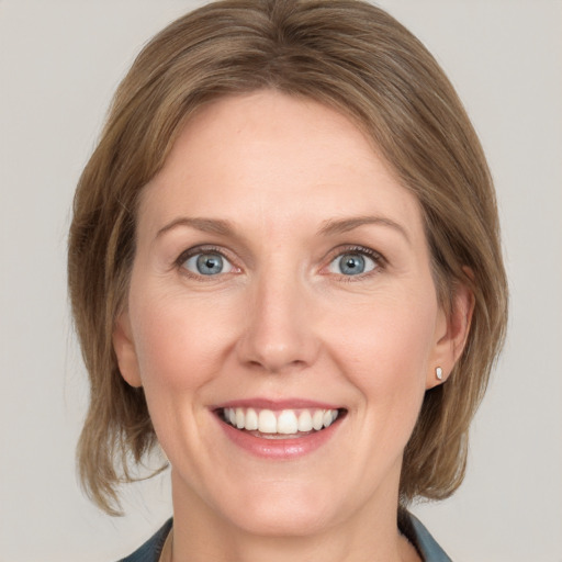 Joyful white young-adult female with medium  brown hair and blue eyes