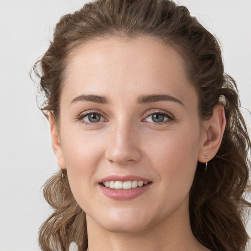 Joyful white young-adult female with long  brown hair and grey eyes