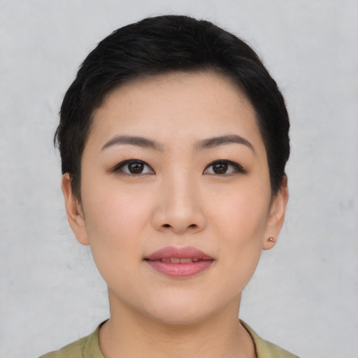 Joyful asian young-adult female with short  black hair and brown eyes