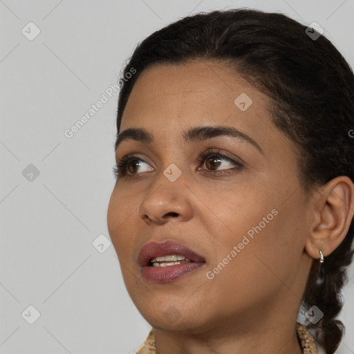 Joyful black young-adult female with long  brown hair and brown eyes