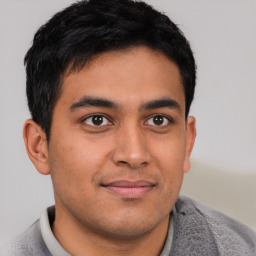 Joyful latino young-adult male with short  brown hair and brown eyes