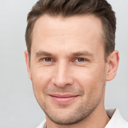 Joyful white adult male with short  brown hair and brown eyes